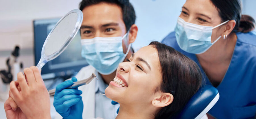 patient looking in mirror as a dentist admires they're work